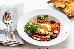 Shakshuka topped with peppers, olives, and feta 